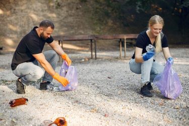 couple-collects-garbage-garbage-bags-park_1157-27358